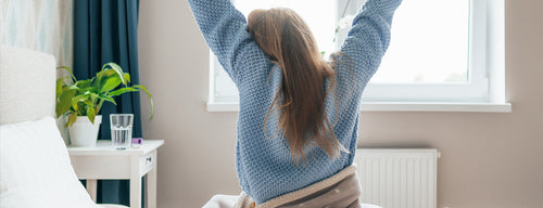 woman stretching after a great night's sleep after implementing healthy sleep habits