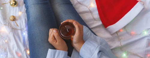 drinking tea with a santa hat and festive lights