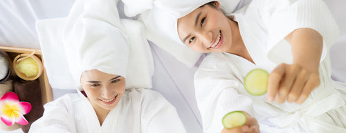two women in dressing gowns with cucumbers