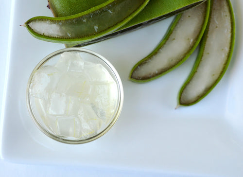 aloe vera drink in a glass with aloe vera slices to the side