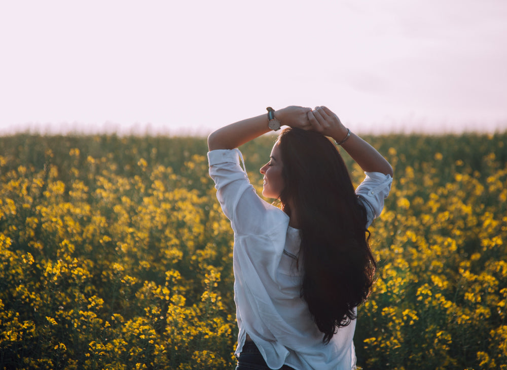 young woman in a field of yellow flowers