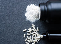 magnesium tablets and powder spilling from black bottles