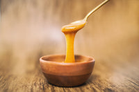 jar of manuka honey on stand with honey dipper