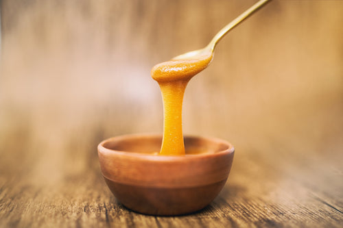 jar of manuka honey on stand with honey dipper