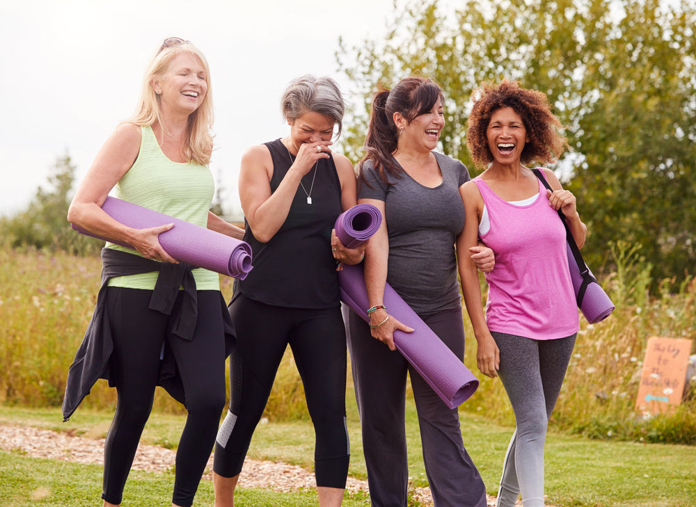 group of women in leisurewear with yoga mats