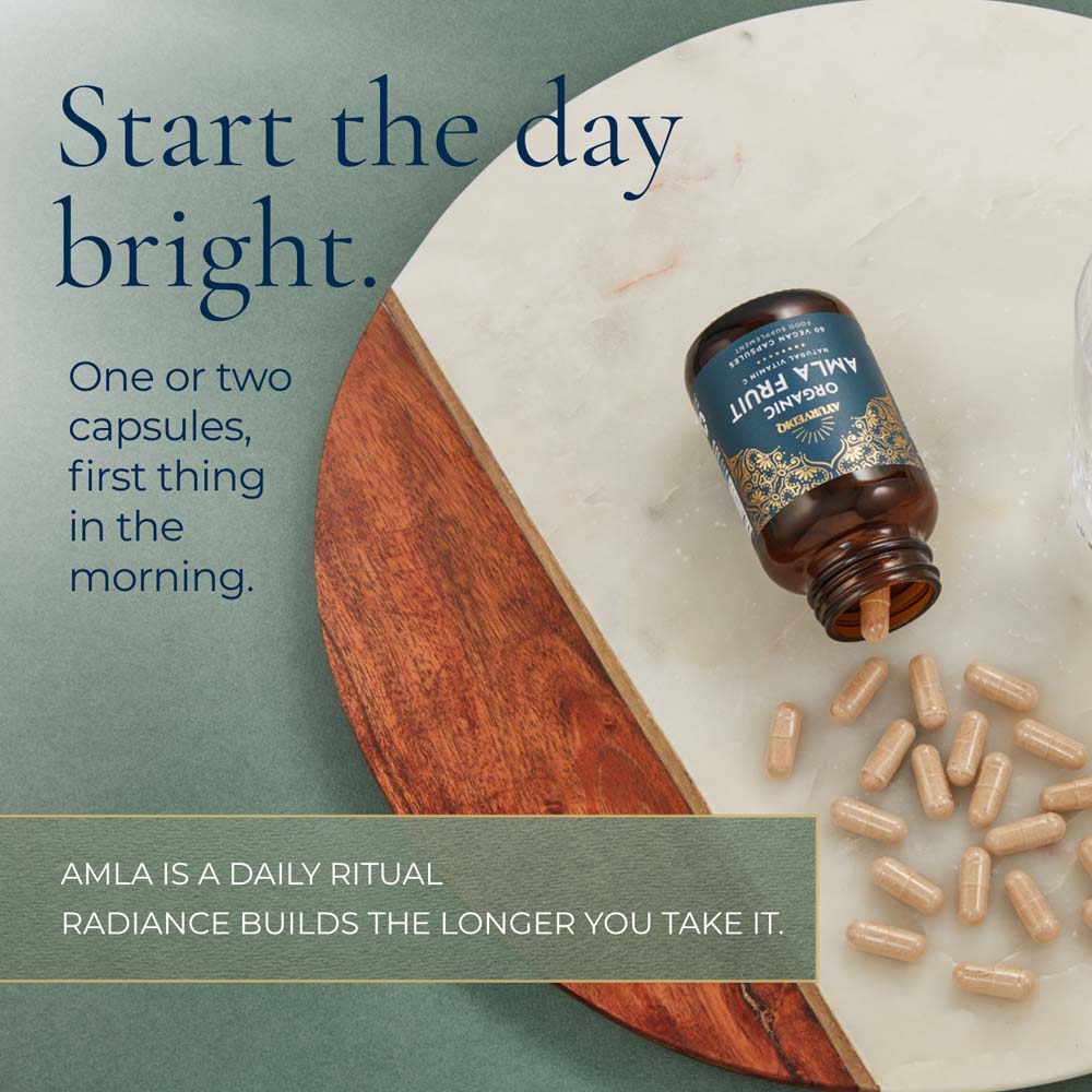 An open amber bottle of AMLA Organic Fruit Capsules. Large text reads &