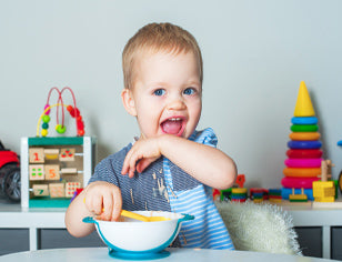 Toddler eating from plastic bowl