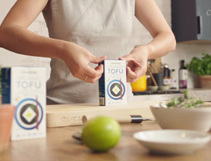 Woman opening box of Clearspring Tofu