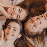 three smiling girls' faces