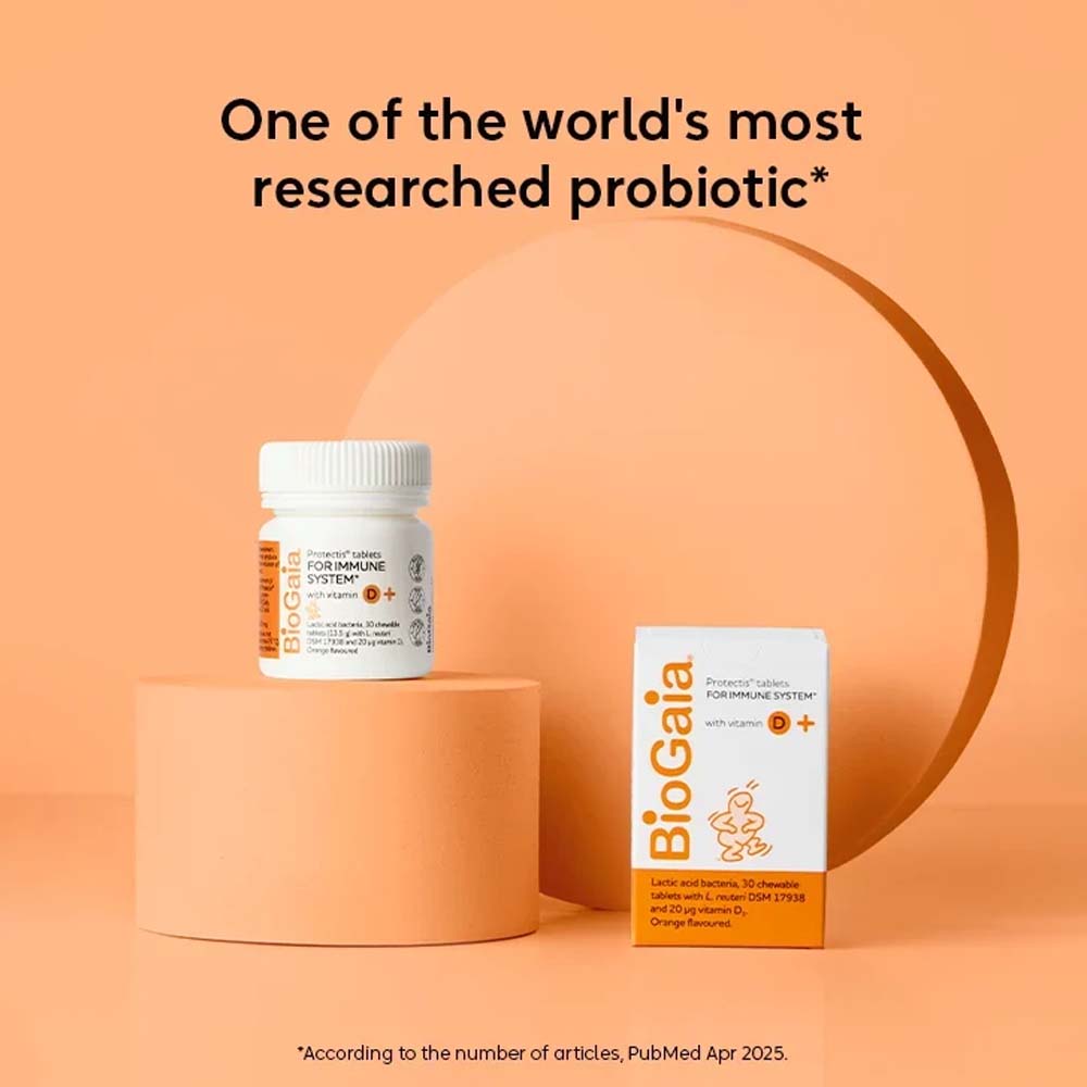 BioGaia Probiotic supplement shown with a white bottle and white-and-orange box on peach-colored pedestals against a peach background, with the headline &