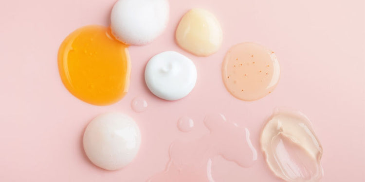 Selection of different textures gels and creams on a pink background