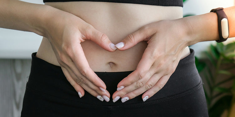 woman holding hands in heart shape over belly