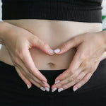 hands making heart shape over tummy