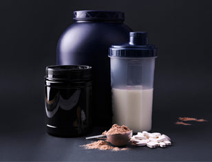 protein tub shaker scoop and supplements on black background