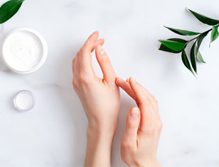 Hands applying hand cream