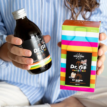 Person holding a bottle and colorful box of Dr. GB Gut Brain supplement.