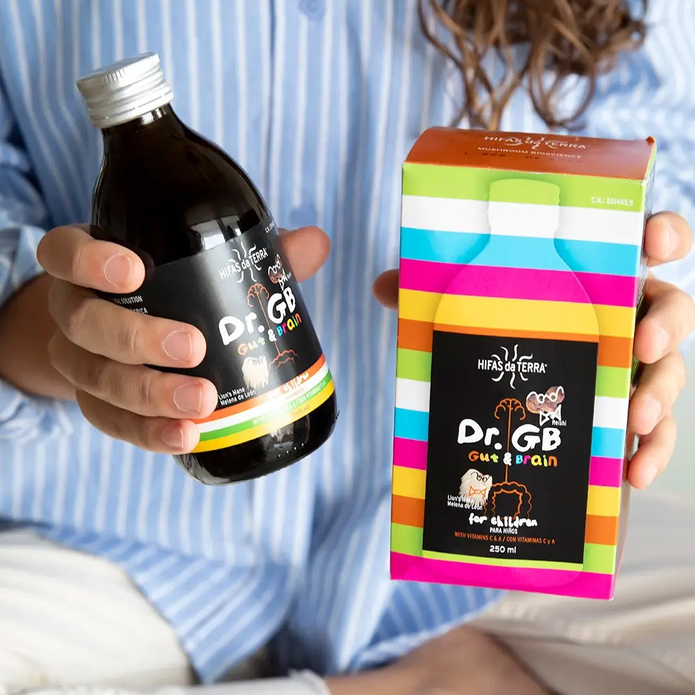 Person holding a bottle and colorful box of Dr. GB Gut Brain supplement.
