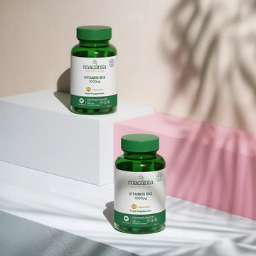 Two bottles of macaánta Vitamin B12 on a light surface with a pink fabric background