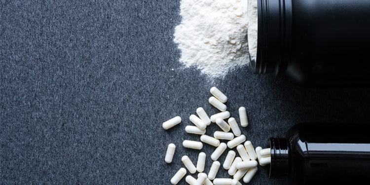 black supplement bottles with capsules and white powder on black background