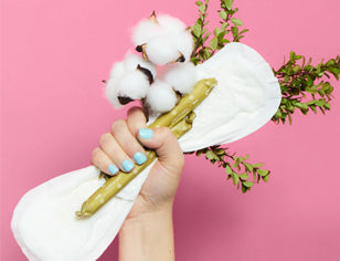 Hand holding sanitary pad and tampon