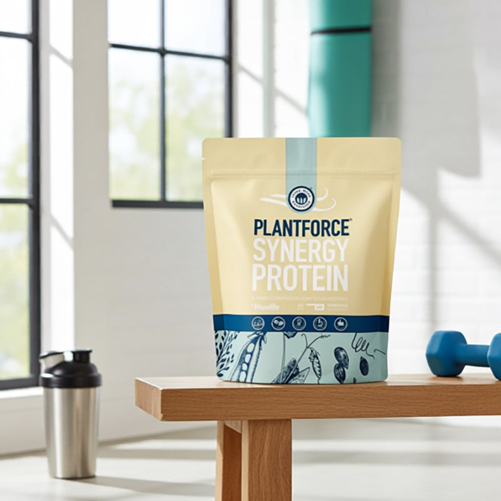 Plantforce Synergy Protein package on a wooden table with fitness equipment in the background