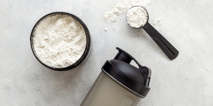 protein powder and scoop with shaker on grey background