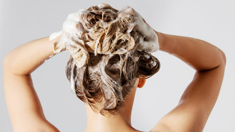 Woman washing hair with shampoo