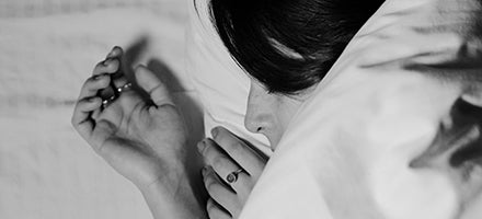 black and white picture of woman asleep under duvet