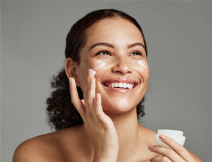 Woman applying sun lotion to face
