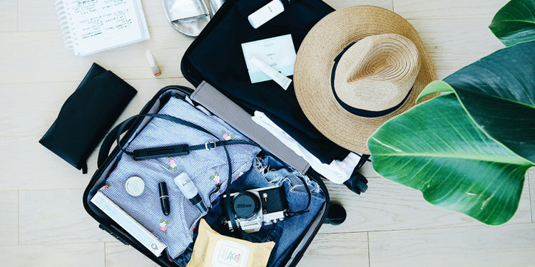 Open suitcase with camera and travel items