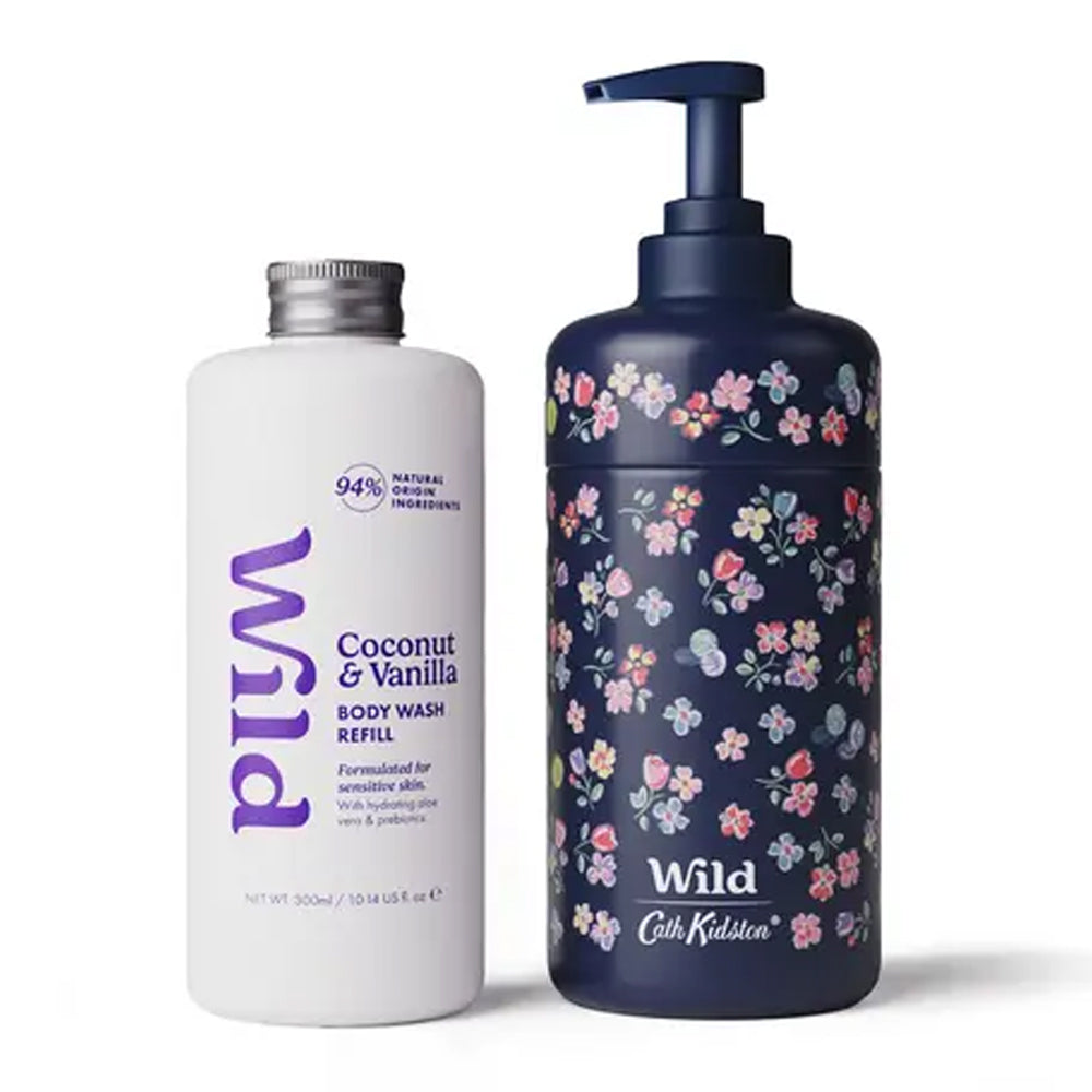 A white bottle of Wild Coconut & Vanilla Body Wash Refill next to a dark navy blue pump bottle with a pink and white floral pattern, both branded with the &