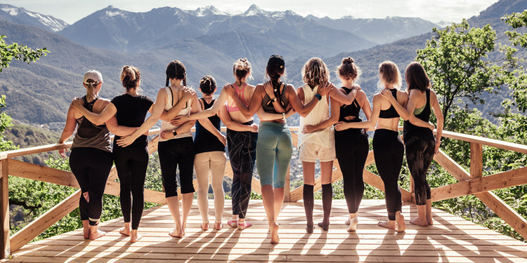 Group of women in mountains with arms around each other