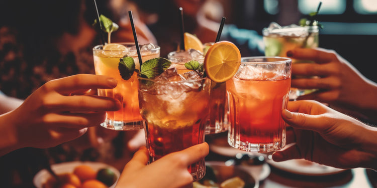 group of people touching cocktail glasses in toast