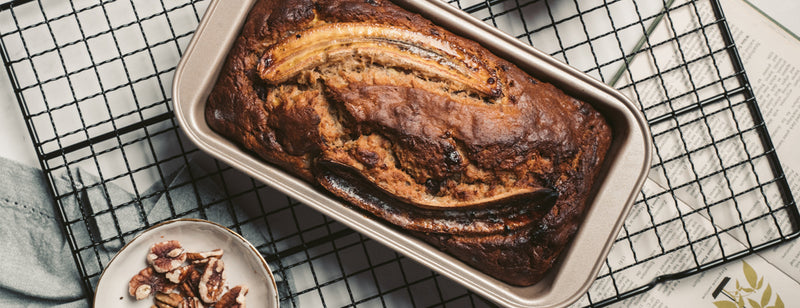 a loaf of banana bread on a wire tin