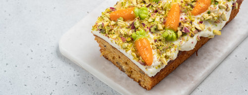 Biona's Easter Carrot Loaf Cake with fresh pistachios on a white plate
