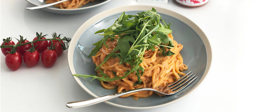 Creamy Tofu Tomato Carbonara with a vine of fresh tomatos