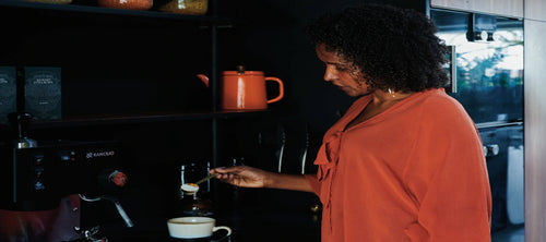 Woman in orange top making a hot drink