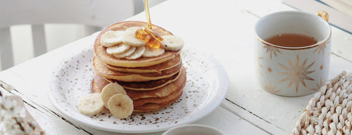 stack of healthy pancakes with honey and bananas