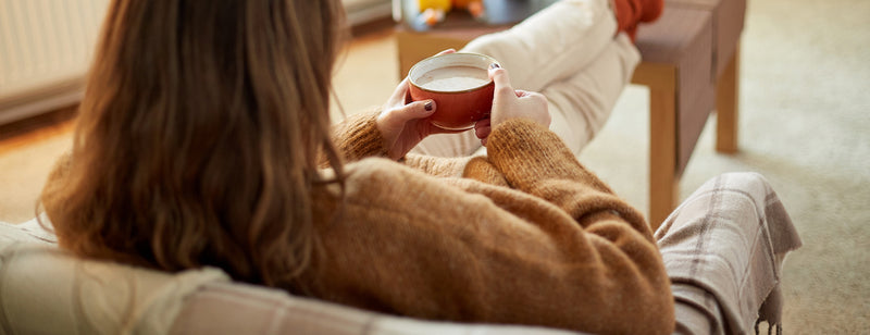 woman drinking a warm drink with herbs and spices in winter