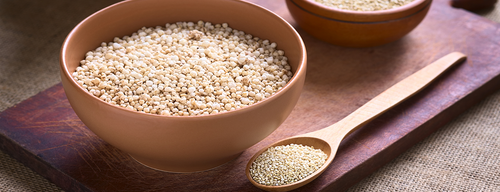 quinoa in wooden bowl with wooden spoon