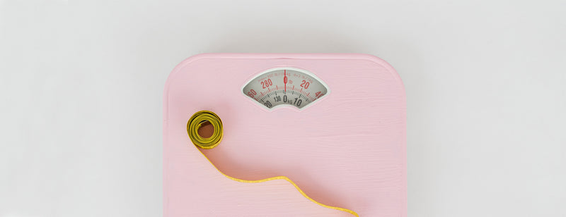 pink weighing scales with measuring tape on it