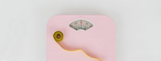 pink weighing scales with measuring tape on it