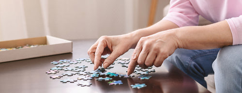 woman doing jigsaw which can be good for brain health and reduce your risk of dementia