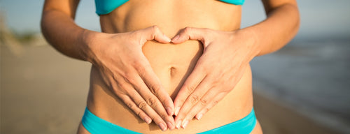 woman making heart shape over her tummy for her digestive health