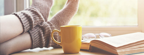 woman in cosy socks with a warm drink during the cold and flu season