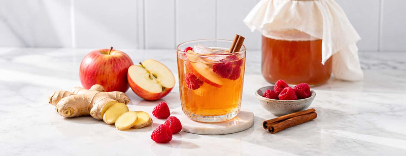 An apple, ginger an berry drink in a glass