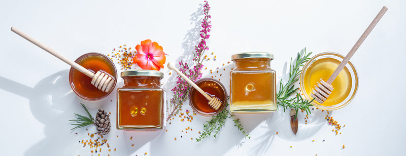 various jars of manuka honey with flowers