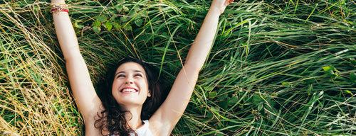 happy woman lying in green field