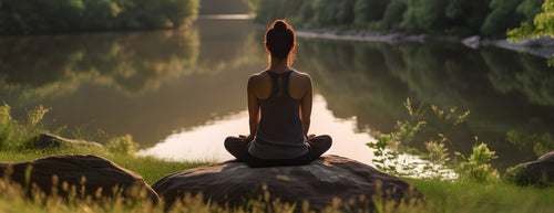 woman relaxing by a still lake