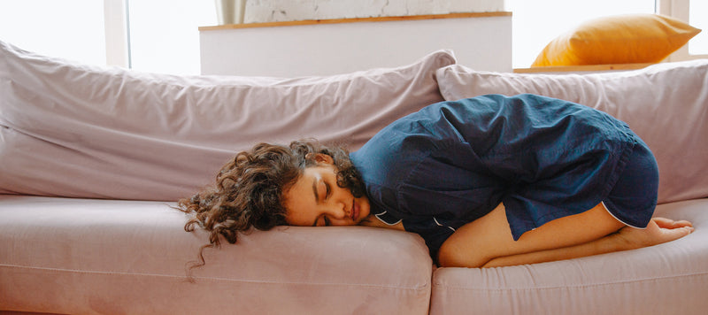 woman in nightshirt curled up on sofa